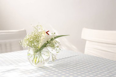 Yuvarlak cam vazo. Beyaz çiçekler. Işık odası. İçi beyaz renkte. Düğün süslemeleri. Parlak mutfak. Sıcak bir yer. Romantik buket. Sıcak, beyaz bir mutfak. Işıkla dolu bir oda..