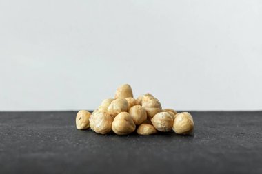 Çikolata için malzemeler. Bir avuç fındık. Hazel meyveleri. İştah açıcı bir resim. Siyah arka planda kavrulmuş fındık. Sağlıklı bir şeyler..