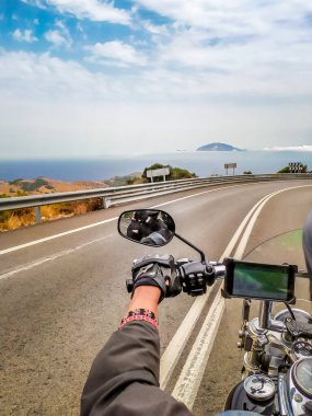 Motosiklet hareket halinde. Bisikletle Avrupa 'yı gezmek. Yol aşkı. Yol işaretleri. Bir motosikletlinin omzunun arkasından bak. Motorlu sürüş.