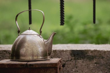 Retro tarzı. Eski çaydanlık. Mutfak aletleri. Barbekü aletleri. Açık hava eğlencesi. Köy hayatı. Dışarıda çay içiyorum. Sıcak içecek. Sakin sakin.