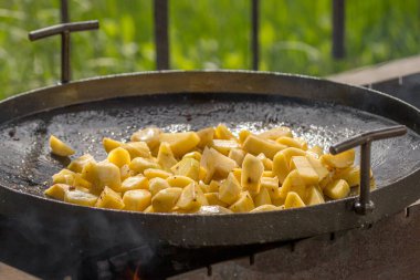 Kızarmış patates. Lezzetli yemek. Açık ateşte pişir. Tavada kızartılmış sebzeler. Köy hayatı. Piknik menüsü. Tabaklar ızgarada.