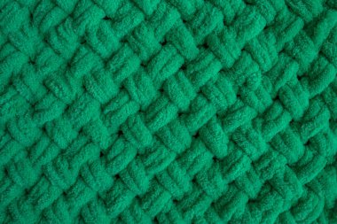 Pelüş iplikten yapılmış yumuşak yeşil ekose. Yumuşak yüzey. Elle örülmüş. Örgü battaniye. Yeşil arka plan. Lüks bir ekose. Kalın giysiler. Isınan şeyler. Noel arkaplanı. Sıcak kış.