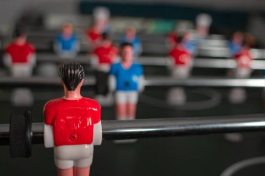 Masa oyunundaki futbolcuların figürleri. Takım çalışması. Masa futbolu. Birimiz hepimiz için. Futbol takımı. Futbol sahasındaki oyuncular. Popüler bir spor. Topla koşmak. Seçkin oyuncu.