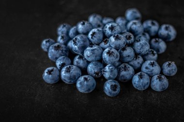 Handful of blueberries on black background. Handful of blueberries Ripe berries. Healthy Lifestyle. Useful products. Lots of vitamins.