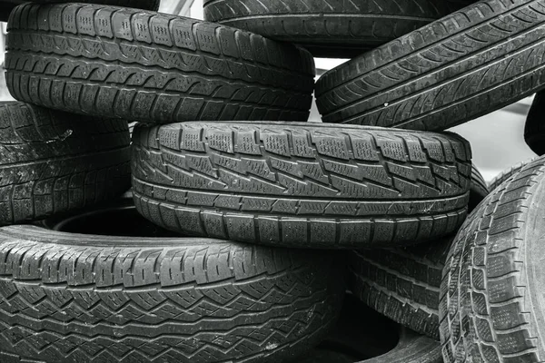 Lots of used car tires to block the road. Used tires. Automobile industry. Wheel element. Tire barricade. A fence made of improvised materials.