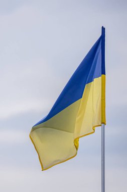 Blue-yellow Ukrainian flag against a cloudy sky. State symbols. Brave Ukraine. The flag flutters in the wind. Patriotic symbol.