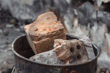 Stone dump on the ruins of a private house. A pile of construction debris and stones. Remains of bricks in a bucket.