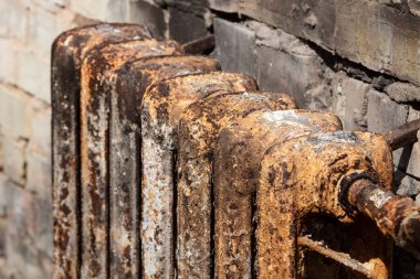 A rusty cast-iron battery in a burnt-out house. A rusty cast-iron battery in a burnt-out house. Cast iron battery. Heating device. The place of the fire. Burnt apartment. Conflagration place. Seat of fire. 