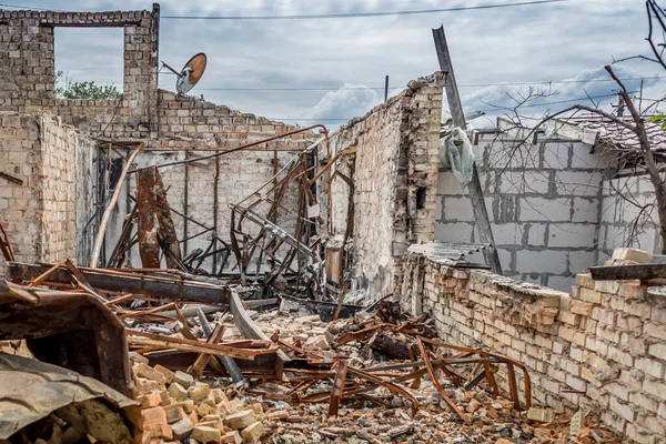 Ruined house. Ruins of a residential building. Brick walls. War in Ukraine. A house destroyed by a rocket and fire. A pile of bricks. A burnt life. Russian peace. Consequences of Russian aggression and occupation.