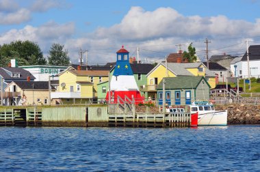 Cheticamp, Kanada - 31 Temmuz 2010: Cheticamp Harbour Lighthouse, Kanada 'nın Nova Scotia eyaletinin Cape Breton kentindeki Cabot Trail' de Acadian bayrağının tasarımında resmedildi.