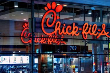 Toronto, Canada  August 8, 2022 Chick-fil-A at Bloor and Yonge with sign on the outside and inside visible. The American fast-food restaurant chain specializes in chicken sandwiches.