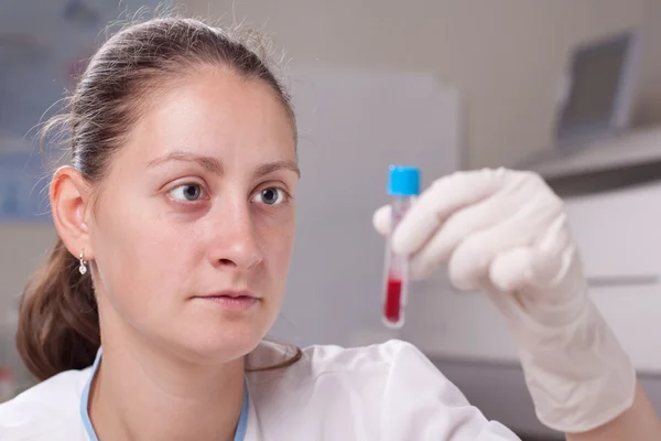 Segurando tubo de teste cheio de sangue — Fotografia de Stock