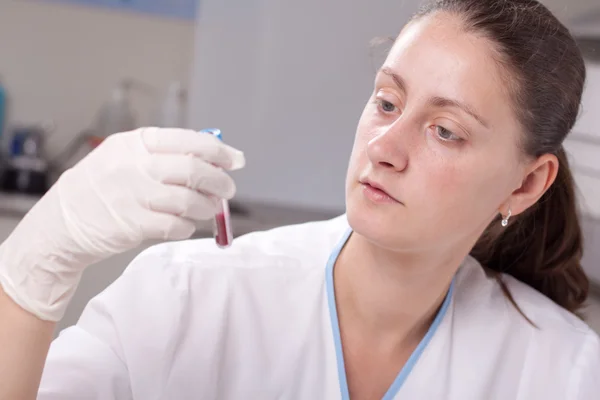 Segurando tubo de teste cheio de sangue — Fotografia de Stock