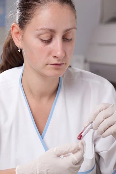 Segurando tubo de teste cheio de sangue — Fotografia de Stock