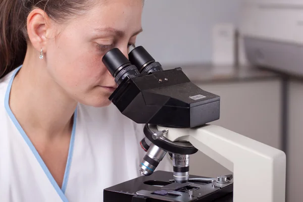 Doctora joven con microscopio —  Fotos de Stock