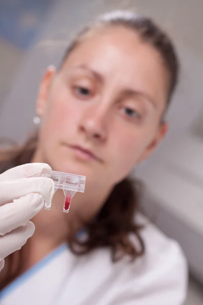 Mulher examinar amostra de sangue — Fotografia de Stock