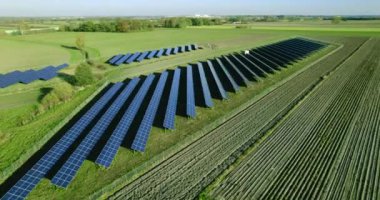Güneş panellerinin inanılmaz hava manzarası yeşil alanlarda bir sırada duruyor. Güneşten yenilenebilir temiz enerji kaynağı. Modern fotovoltaik güneş panelleri sıraları.