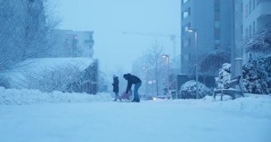 Baba ve oğul karda oynuyorlar. Babam tatmin olmuş oğlunu alacakaranlıkta kızakla sürüklüyor. Kış boyunca konutların avlusunda oyun konsepti.  