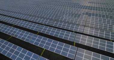 Güneş panelleri yeşil alanlarda bir sırada duruyor. Güneşten yenilenebilir ekolojik enerji kaynağı. Kamera sağa hareket ediyor ve sıra sıra fotovoltaik hücreleri, güneş toplayıcılarını gösteriyor..