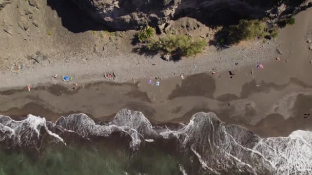 大加那利岛上的Playa Guigui海滩的空中静止图像 夏天阳光灿烂的日子里美丽的海浪 俯瞰在黑暗沙滩上休息的人们 — 图库视频影像