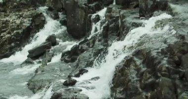 Kayalık dağın dik yamacındaki güzel şelalenin yakın çekimi. Norveç fiyortlarında muhteşem bir manzara..