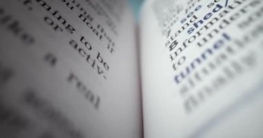Açık kitabın içinde uç makro görünüm. İngilizce metinli kapanış sayfaları. Kitap sayfaları arasında hareket eden bir kamera. Ayrıntılı görünümlü İngilizce metin içerisindeki Macro görünüm beyaz sayfaları.