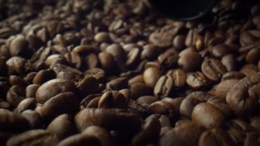 Kahve tohumlarını kapat. Kavrulmuş kahve çekirdekleri barista tarafından kaşık olarak alınır. Kahveli fasulye makro görüntüsünü topluyorum..