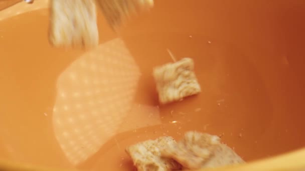 朝食のシナモンコーンフレークをオレンジのボウルに入れます 健康食品のコンセプト — ストック動画