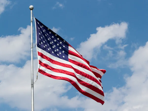 Μας σημαία κυματίζει στο μπλε συννεφιασμένο ουρανό — Φωτογραφία Αρχείου