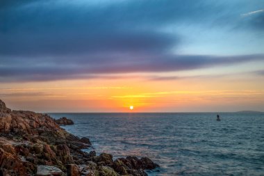 Atlantik Okyanusu üzerinde gün doğumu, Acadia Ulusal Parkı 'ndaki Bass Harbor Head' in kayalık sahillerinden görülmektedir. Doğu Maine 'deki Çöl Adası.