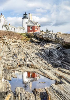 Tarihi Pemaquid Point Deniz Feneri 'nin bir yansıması Atlantik Okyanusu ile Bristol, Lincoln County, Maine' deki bu dönüm noktası deniz feneri arasındaki güzel granitle çevrili bir su birikintisinde görülüyor..
