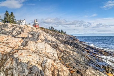 Bristol, Maine yakınlarındaki tarihi Pemaquid Point Deniz Feneri 'nin altında Atlantik Okyanusu' ndan ilginç ve güzel bir kaya kıyısı yükseliyor..