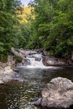 A popular swimming hole, Bust Your Butt Falls is a small waterfall on the Cullasaja River in Nantahala National Forest near the town of Highlands in the beautiful mountains of western North Carolina.