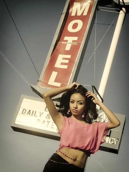 Mooie jonge vrouw poseren naast klassieke Amerikaanse verkeersbord van motel op route 66 — Stockfoto