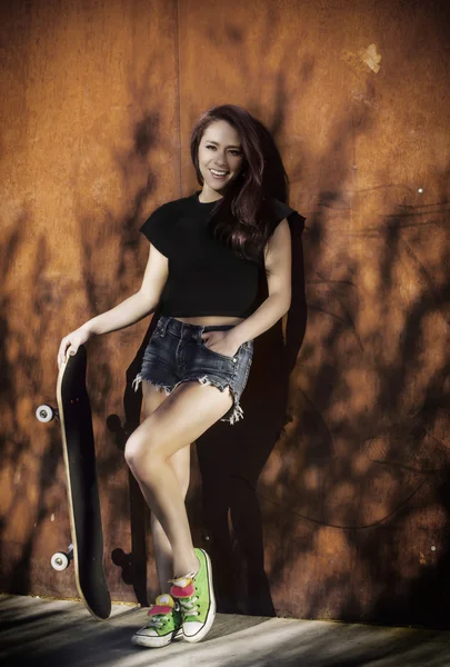 Жінка тримає скейтборд — стокове фото