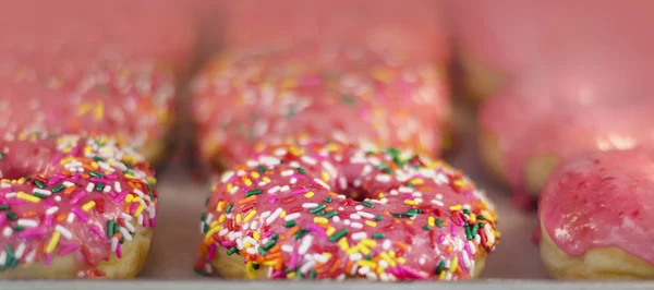 Frosted  pink sprinkled donuts — Stock Photo, Image