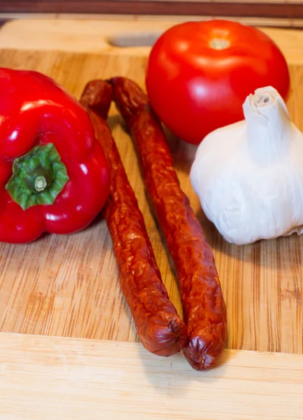 Board with sausages and vegetables — Stock Photo, Image