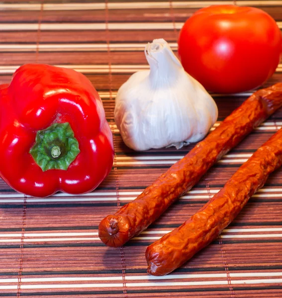 Vegetables and sausages on a table — Stock Photo, Image