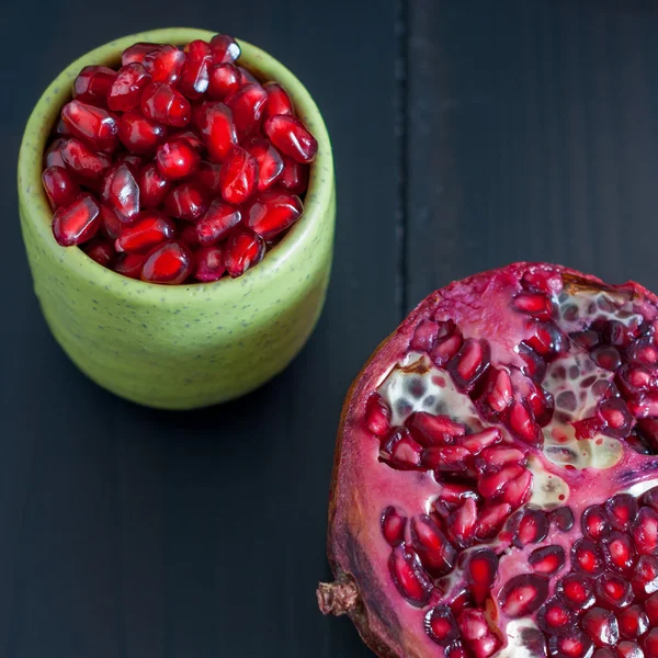 Pomegranate seeds portion in green pottery — Stock Photo, Image