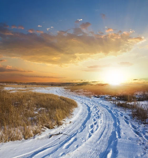 Pôr do sol em uma planície com neve de inverno — Fotografia de Stock