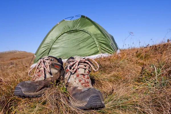 Par turistiska stövlar nära ett tält — Stockfoto