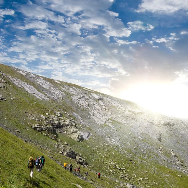 Grupo de turistas que atraviesan una pendiente de monte — Foto de Stock