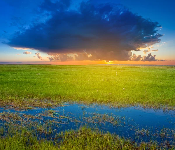 Dramatischer Sonnenuntergang über grünen Hügeln — Stockfoto