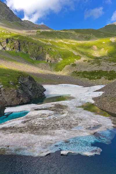 Изумрудное горное озеро со льдом — стоковое фото