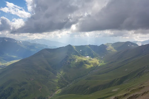 Dichte wolken boven een groene bergen — Stockfoto