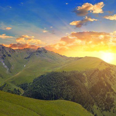 yeşil dağların üzerinden günbatımı