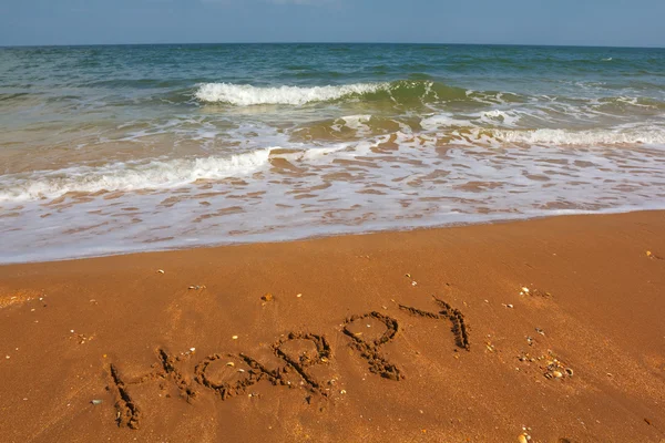 Happy sign on a sand