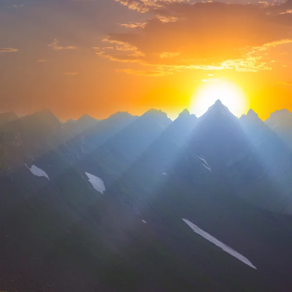 Pôr-do-sol dramático sobre um pico de montanha — Fotografia de Stock