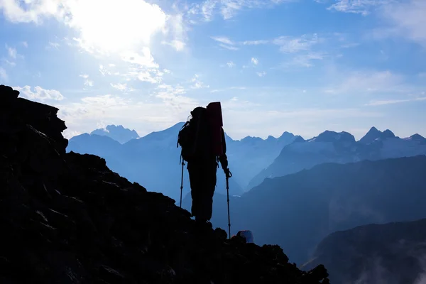 Hiker siluett på en berg-slutta — Stockfoto