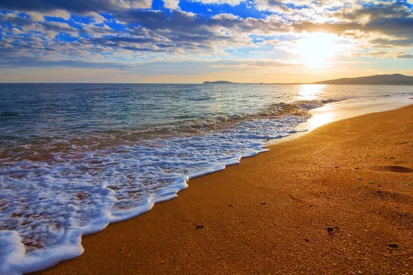 Песчаный морской пляж на восходе солнца — стоковое фото